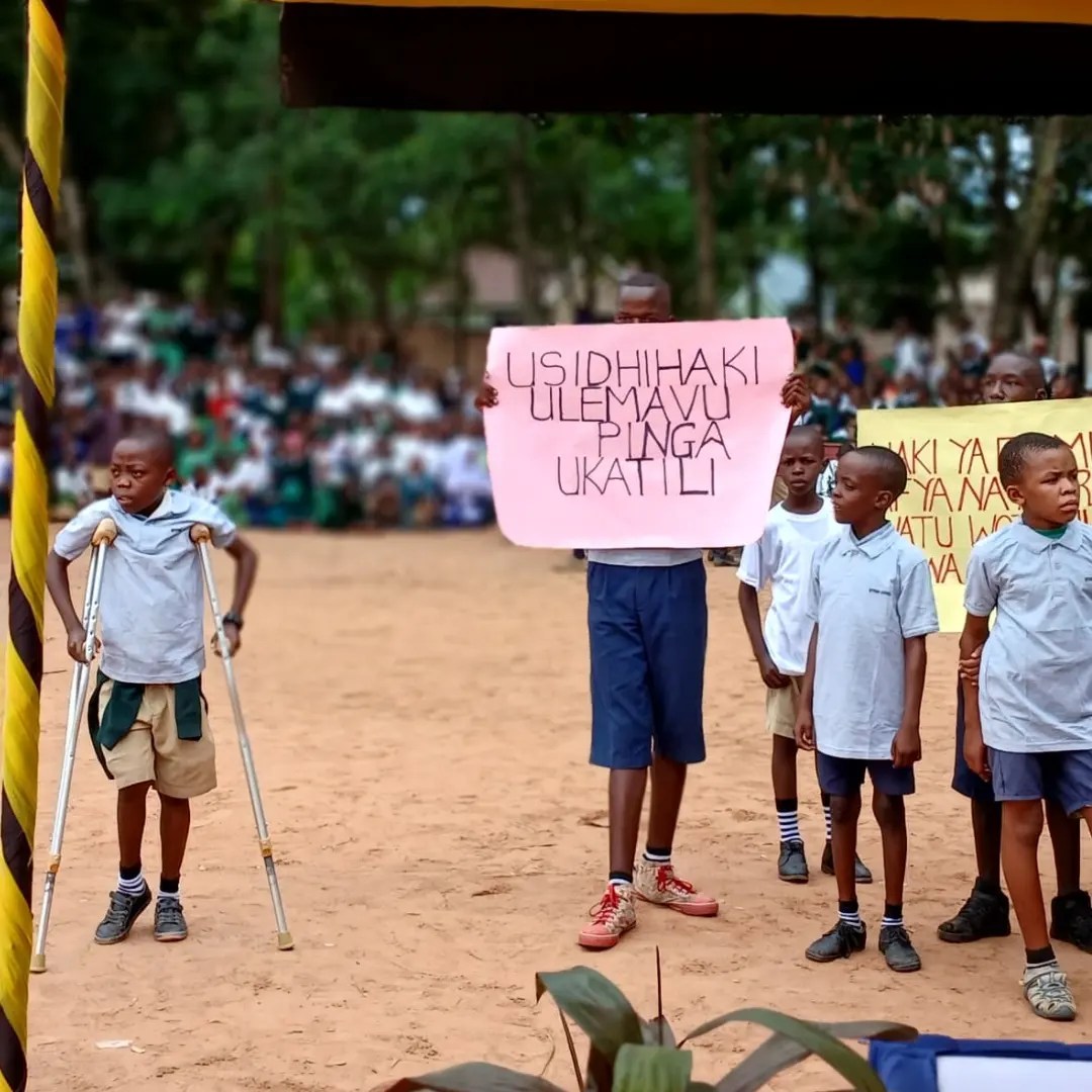 Children and youth raising awareness against violence and discrimination during a community event
